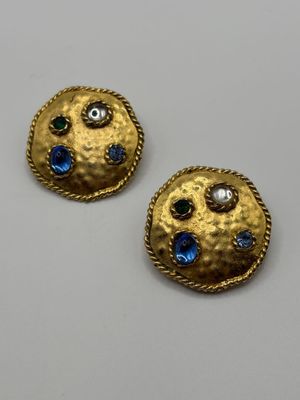 a pair of earrings with blue and green stones on them