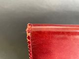 a close up of a red leather wallet on a table