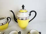 quatre tasses et une théière posées sur une table