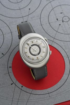 une montre posée sur une feuille de papier, sur une table
