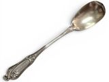 a silver spoon with a spoon handle on a white surface