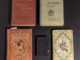 several books are sitting on a table with a black background