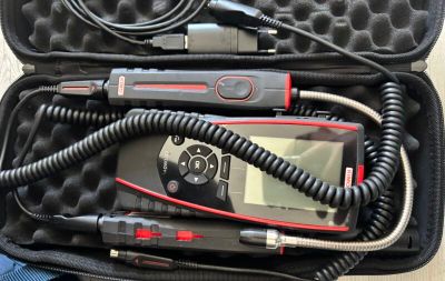a case with a remote, a microphone, and a cell phone in it