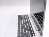 a silver laptop with a black keyboard on a white surface