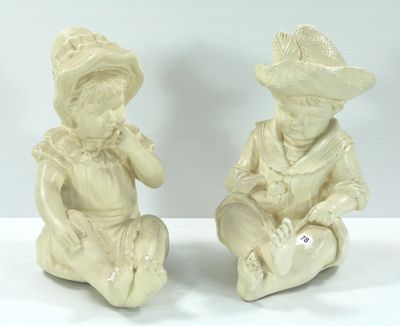 deux figurines représentant un garçon et une fille assis par terre
