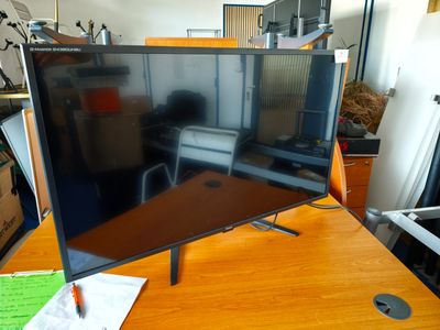 un grand téléviseur à écran plat posé sur un bureau en bois