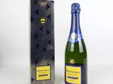 the bottle of champagne is next to a box of chocolates