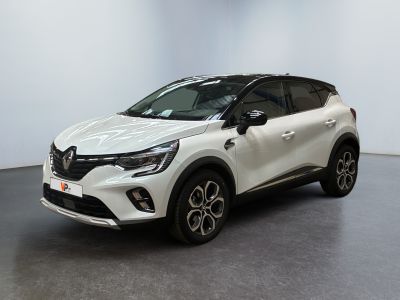 Une voiture blanche est garée dans une pièce au sol noir.