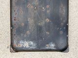 a piece of metal on the ground that has rust on it