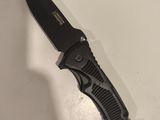 a black knife that is laying on a table