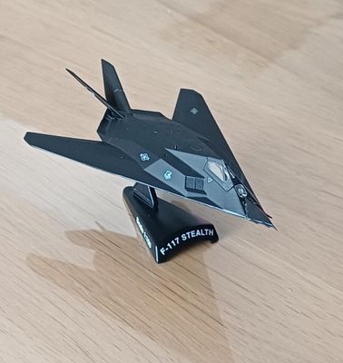 une maquette d'avion de chasse posée sur une table en bois