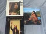 Trois vinyles des années 1970, dont le premier album, sont posés sur un lit