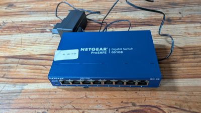 une photo d'un routeur Netgear bleu posé sur une table en bois