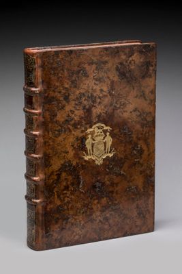 un vieux livre avec un emblème en or sur la couverture