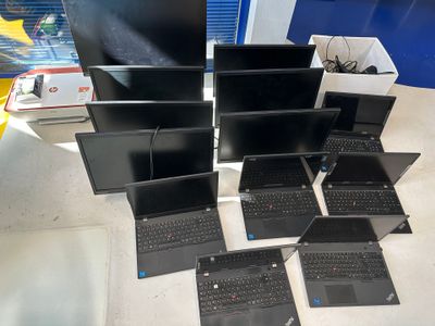 Plusieurs ordinateurs portables sont posés sur une table devant un téléviseur