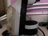 a coffee maker sitting on the floor next to a wall