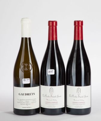 three bottles of red and white wine sitting next to each other