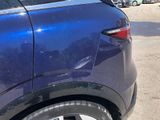 a blue car parked in a parking lot with other cars in the background
