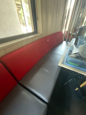 une photo d'une cabine rouge et noire sur laquelle est posée une tasse de café