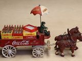 a toy horse pulling a cart with coca cola on it