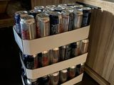 a stack of cans of soda sitting on a kitchen counter
