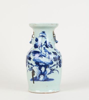 un vase bleu et blanc posé sur une surface blanche