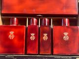 un coffret rouge contenant quatre bouteilles, posé sur une table