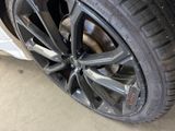 the tire of a white car in a garage with a flat tire