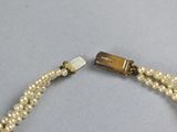 an image of a close up of a bracelet with pearls on it