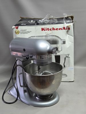 un robot de cuisine KitchenAid argenté, avec une boîte en arrière-plan