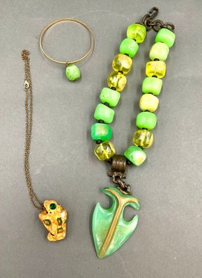 collier, bracelet et bague avec des perles vertes et jaunes sur un fond gris