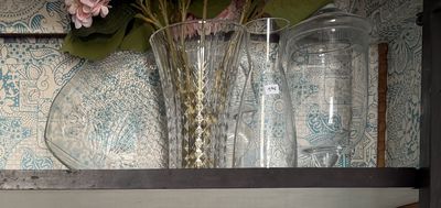deux vases avec des fleurs posés sur une étagère dans une pièce