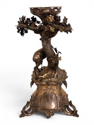 an image of a bronze statue of a tree with a bird on top of it