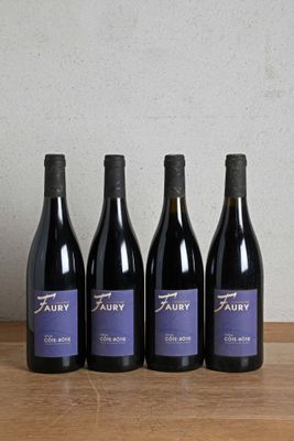 four bottles of wine are lined up on a wooden table