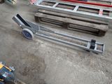 a dolly that is sitting on the ground next to some pallets