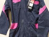 blue and pink coverall with pink trims on a hanger on a wall