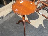 une petite table avec un plateau en bois, devant laquelle se trouve un fauteuil à bascule