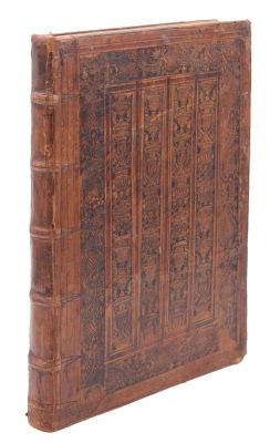 un vieux livre relié en cuir, dont la couverture est ornée de sculptures raffinées