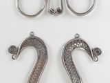 three pieces of silver metal are shown on a white surface