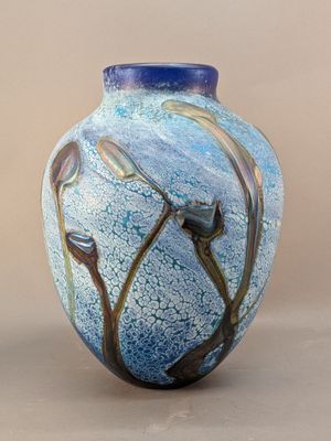 a blue vase with a flower on it on a table