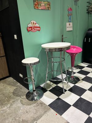 two stools and a table in the corner of a room