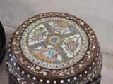 a small wooden stool with a decorative design on it