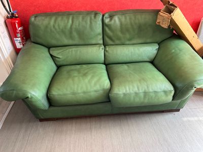 un canapé en cuir vert qui se trouve dans une pièce