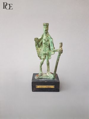 statue en bronze représentant un homme muni d'une épée et d'un bouclier, posée sur un socle en marbre