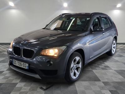 une photo d'un SUV BMW gris garé dans un garage