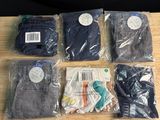 six paires de jeans pour homme, dans des sacs, posées sur une table