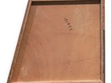 an old wooden tray with writing on it sitting on a white surface