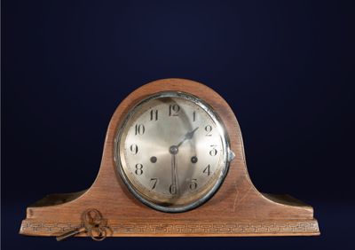 une horloge en bois surmontée d'une clé