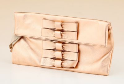 beige clutch bag with bow detail on the front