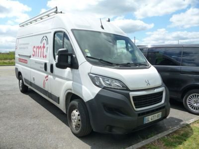 une camionnette blanche garée sur un parking à côté d'une voiture noire